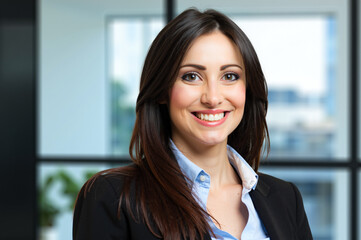 Smiling businesswoman portrait in modern office setting