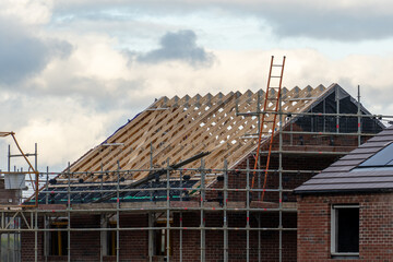 Roofing a property on a building site. New build housing in the suburbs. Construction concept.