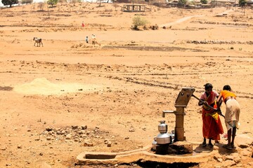 Tribal woman pumping water from hand pump, India, Asia