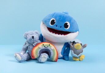 Different soft toys on a blue background, the concept of friendship and togetherness