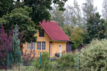 
a yellow wooden house with a red roof