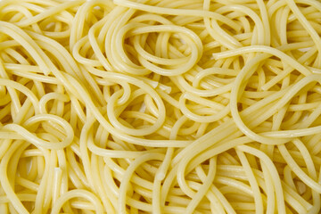 Cooked spaghetti background. Close-up spaghetti texture with concept of abstract, cooking, pasta, ingredients, eating healthy, yellow, and food culture. Food texture background of cooked spaghetti.