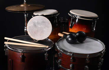 Different drums on a black background, percussion musical instruments