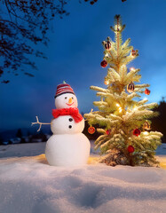 Obraz premium A snowman next to a Christmas tree decorated with Christmas ornaments isolated snow background