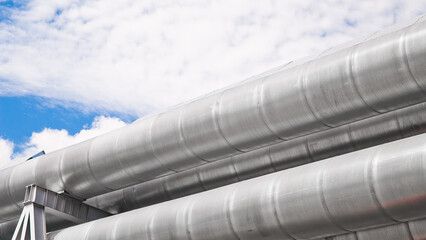 The photo shows a pipeline against the background of blue sky and clouds