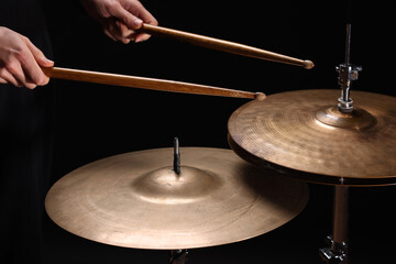 Drummer playing drums, different percussive musical instruments on a black background
