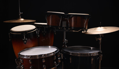 Different drums on a black background, percussion musical instruments