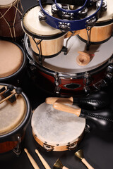 Different drums on a black background, percussion musical instruments