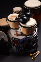 Different drums on a black background, percussion musical instruments