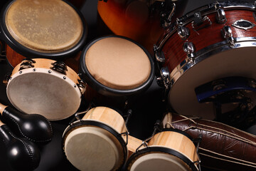 Different drums on a black background, percussion musical instruments