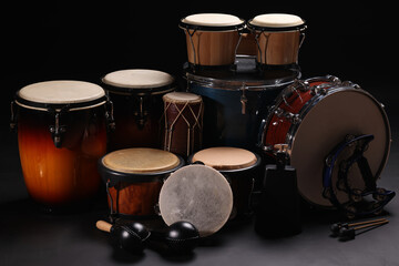 Different drums on a black background, percussion musical instruments