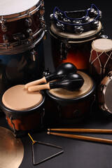 Different drums on a black background, percussion musical instruments