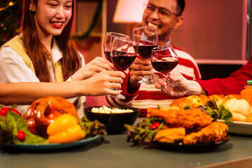 Lively New Year Eve and christmas party Asian friends and colleagues of various ages celebrating together. Champagne, wine, gift boxes, festive decorations create a warm, joyful holiday atmosphere.