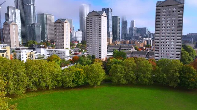 Canary wharf skyline reveal from Durand&rsquo;s Wharf autumnal park - London. 