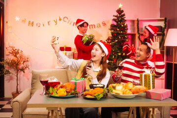 Lively New Year Eve and christmas party Asian friends and colleagues of various ages celebrating together. Champagne, wine, gift boxes, festive decorations create a warm, joyful holiday atmosphere.