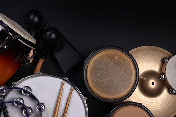 Different drums on a black background, percussion musical instruments