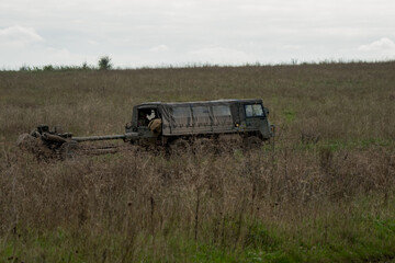 British army bae systems, Puch, Daimler, Pinzgauer High-Mobility All-Terrain 6x6 vehicle towing a 105mm Light Artillery Gun on a military exercise © Martin