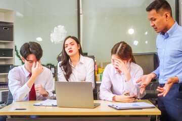 Two men and two women, including boss and employees, discuss recent mistake. Expressions of disappointment and constructive criticism create a tense, reflective atmosphere around laptops and desks.