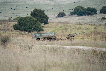 British army bae systems, Puch, Daimler, Pinzgauer High-Mobility All-Terrain 6x6 vehicle towing a 105mm Light Artillery Gun on a military exercise © Martin