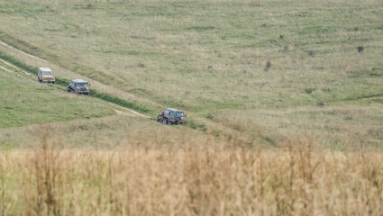 a pair of British army bae systems, Puch, Daimler, Pinzgauer High-Mobility All-Terrain 6x6 vehicles towing a 105mm Light Artillery Guns on a military exercise © Martin
