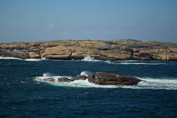 scissor islands off sm&ouml;gen in sweden, with bright sunshine and small white clouds