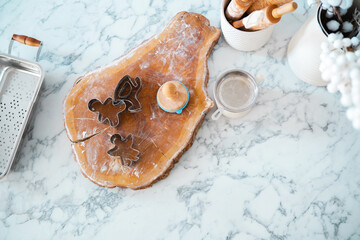 Baking festive cookies with cutters on a marble countertop in a cozy kitchen