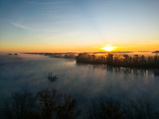 sunrise over a lake with fog setting a spooky mood