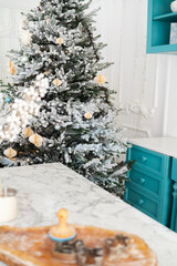 Festive Christmas tree adorned with decorations in a cozy kitchen setting
