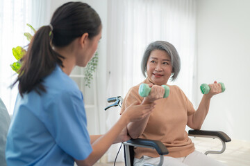 Friendly caregiver helping senior woman with dumbbell exercise at home, supporting health, wellness, and active aging. Elderly care assistance for physical therapy and trust.