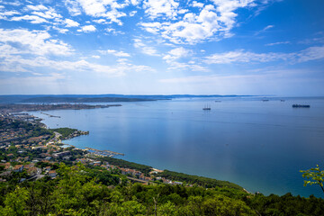 A large, expansive body of water appears, with a city located in the distance