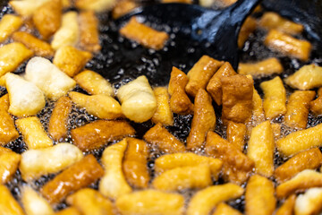 The dough is fried in pieces in a pan in oil (Pa Thong Ko), Baursaks or chak chak is a traditional national dish.