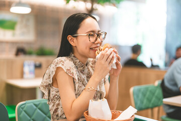 Portrait of asian woman eating japanese hamburger