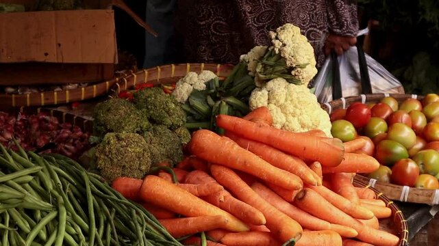 close-up of carrots and tomatoes sold at a traditional market stall