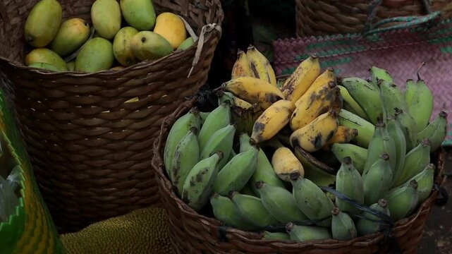 a wooden basket filled with green and yellow bananas, a traditional fruit