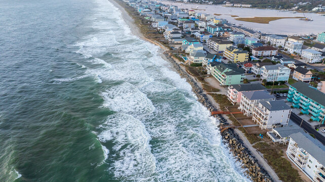 Aerial view of coastal residential properties vulnerable to climate change effects, facing rising insurance costs and increased risk from hurricanes and natural disasters.