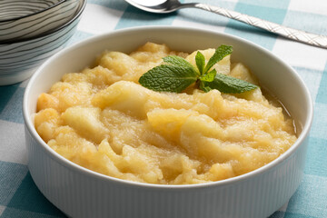Ceramic bowl with organic homemade apple compote on the table close up for dessert 