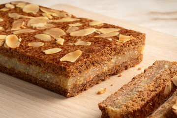 Piece of typical Dutch treat called gevulde speculaas and slices to be served at Sinterklaas evening on a cutting board close up 