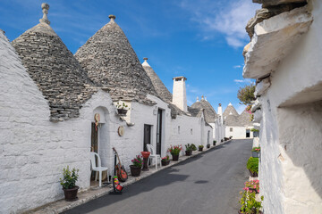 Narrow street in ancient southern Italian town with traditional trulli dwellings, Alberobello, Italy