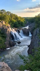 Obraz premium A serene view of cascading waterfalls along the Potomac River at sunset, surrounded by lush greenery and rocky cliffs