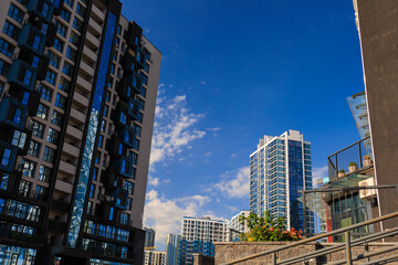 Obraz premium City view, modern buildings and skyscrapers against the blue sky.