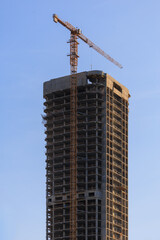Construction cranes and new buildings, construction work of modern skyscrapers on a sunny day.