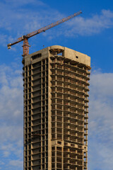 Construction cranes and new buildings, construction work of modern skyscrapers on a sunny day.