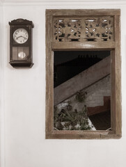 an old window with an old wall clock next to it