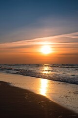 Sandy beach with the sun in the background. Beautiful sunset over the Baltic Sea in Gdynia, Poland.