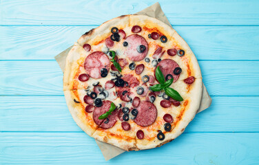 Pizza with mozzarella cheese , salami sausages , olives , and basil
