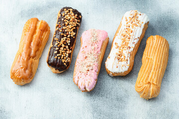 Assorted eclairs on a pastel top view Traditional French dessert