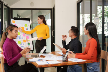 Group of Asian businessmen are sitting in a meeting, talking, exchanging knowledge. Presentation about office work