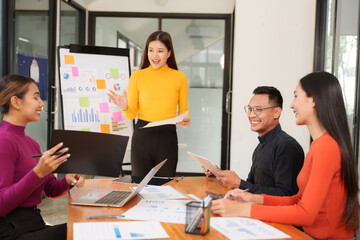Group of Asian businessmen are sitting in a meeting, talking, exchanging knowledge. Presentation about office work