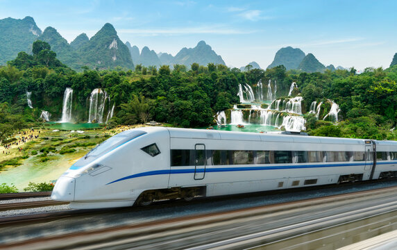 The high-speed train travels through beautiful scenery
