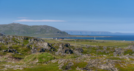 Scenic view of a rocky shore, mountains and fjords with Berlevag mountainscape in background at Finnmark, Norway